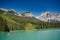 Beautiful scenery of people kayaking in a lake surrounded by trees and mountain in Banff and Jasper