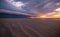 Beautiful scenery of a sandy beach under the breathtaking cloud formations during sunset