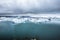 Beautiful scenery of small blue icebergs in Jokulsarlon ice lake and very gray sky in Iceland