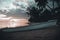 Beautiful scenery of a white rafting boat at the sandy beach of Moorea island during a cloudy sunset