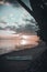 Beautiful scenery of a white rafting boat at the sandy beach of Moorea island during a cloudy sunset