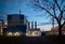 Beautiful scenic of petrochemical oil refinery plant shines with red and white lights at night with tree on foreground and copy