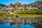 Beautiful scenic view of Ganden Sumtseling monastery with water reflection at sunset and blue sky Shangri-La Yunnan China