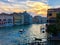 A beautiful scenic view of a single water taxi boating down the grand canal as the sun sets