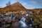 Beautiful Scotland waterfall with blue sky and snowcapped mountain. Taken at Buachaille Etive mor, Glencoe, Scottish Highlands.