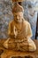 The beautiful sculptured statue of Buddha sitting in meditation with closed eyes on the lotus flower with structures craved on the