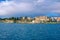 Beautiful sea bay with calm blue water, cruise boats and mountains on the horizon