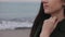 Beautiful sea at sunrise. Close up blurred view of a young girl with her left hand on her neck. Focus shifting from the