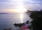 Beautiful sea sunset in purple color tone with an empty stone beach and beach towels on it