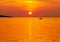 Beautiful sea sunset in yellow and orange color tone with small fishing boat