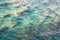 Beautiful sea water texture design detail with rocks and beautiful emerald green turquoise color, close up