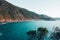 Beautiful seascape with blue sky, smooth water surface and rocky cliffs.