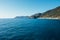 Beautiful seascape with blue sky, smooth water surface and rocky cliffs.