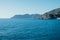 Beautiful seascape with blue sky, smooth water surface and rocky cliffs.