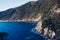 Beautiful seascape with blue sky, smooth water surface and rocky cliffs.