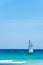 Beautiful seascape, a boat with a white sail on turquoise waves. Exotic Caribbean sea and clear blue sky. Yachting and