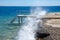 Beautiful seascape of the Egyptian coast, Red Sea, waves breaking into splashes on the pier, bridge for boarding and disembarking
