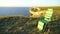 A beautiful seascape, a green tourist chair stands on the edge of a cliff, a strong wind blows from the ocean