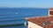 Beautiful seascape looking at the ocean past a red Spanish tile roof in a tropical resort