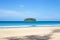 Beautiful seascape. Small round island in the sea covered with tropical greenery, blue sky on the horizon.Travel and