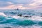 Beautiful seascape at sunset, a wave with clear water, a boat with fishermen on the horizon.