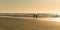 Beautiful seascape with surfer walking along the beach