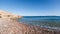 Beautiful seascape of wild shingle beach, blue Aegean sea and Greek island Symi in the background. Datca, province of Mugla Turkey