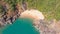 Beautiful secret beach Butterfly in Goa, India. Aerial view of pristine beach with rocky bay and waves crashing.