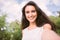 Beautiful self portrait of young brunette smiling woman on nature and sky background in the park. Travel. Selfie.