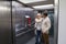 Beautiful senior couple with luggage standing in modern elevator