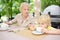 Beautiful senior lady with his little grandson drinking tea in outdoors cafe or restaurant. Elderly lady lifestyle