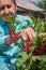Beautiful senior woman picking homegrown redcurrants