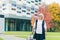 Beautiful senior woman travels with a large travel suitcase, on the background of a beautiful modern building	 Category	 People