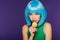 Beautiful sensual girl in blue wig posing with sweet tasty macaron isolated