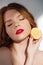 Beautiful sensual redhead girl with red lips posing with cut lemon.