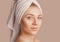 Beautiful sensual young girl with clean skin on a beige background with a mockup. Topless woman in a towel. The concept of spa