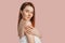 Beautiful sensual young girl with clean skin on a pink background with a mockup. Topless woman in a towel. The concept of spa