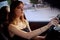 Beautiful serious girl sit in a car at twilight