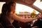 Beautiful serious girl sit in a car at twilight