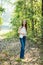 A beautiful serious teen brunette girl looking away from the camera towards the future in a wooded area in the spring