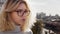 Beautiful serious teenage girl with glasses looking away in city