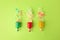 Beautiful serpentine bursting out of small party poppers on green background, flat lay