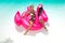 Beautiful sexy, amazing young woman in a swimming pool sitting on an inflatable pink flaming and laughing, tanned body, long hair