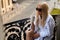 Beautiful sexy blonde in a white bathrobe and sunglasses sits on the balcony with a cup of coffee