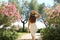 Beautiful sexy fashion woman enters in a garden between flowers in Sirmione on Lake Garda, Italy