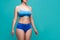 Beautiful sexy woman in blue underwear on turquoise background, perfect female body