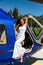 Beautiful sexy woman with dark hair in luxurious dress posing near blue helicopter