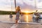 Beautiful sexy woman in dress relaxing on a yacht front at sunset