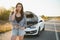 Beautiful sexy woman near a broken car. Confused woman does not know what to do