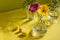 Beautiful shadows from glass vases in sunlight. Gerberas in glass bottles on a yellow background. A floral minimalistic concept in